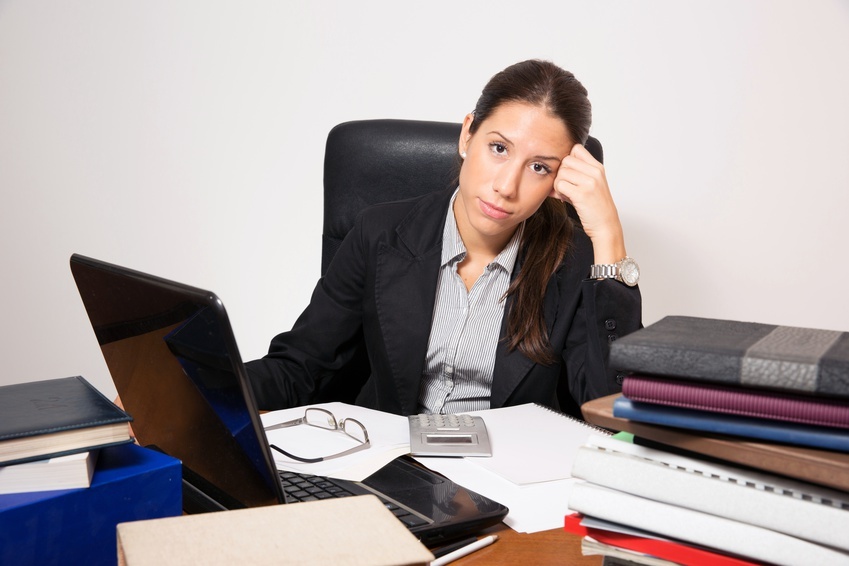 Young business dressed woman working at office desk.